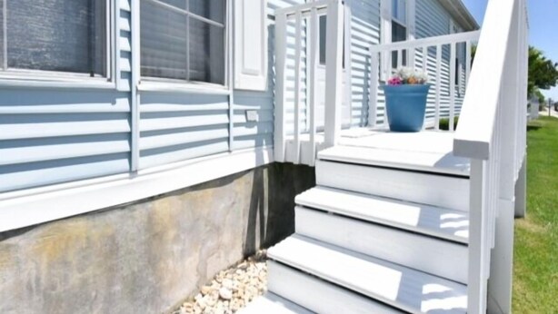 A white house with a front porch and a blue flower pot. - 3 BR 2 Bath Home featuring spacious deck 2 living areas 2 Community pools (Ocean City)