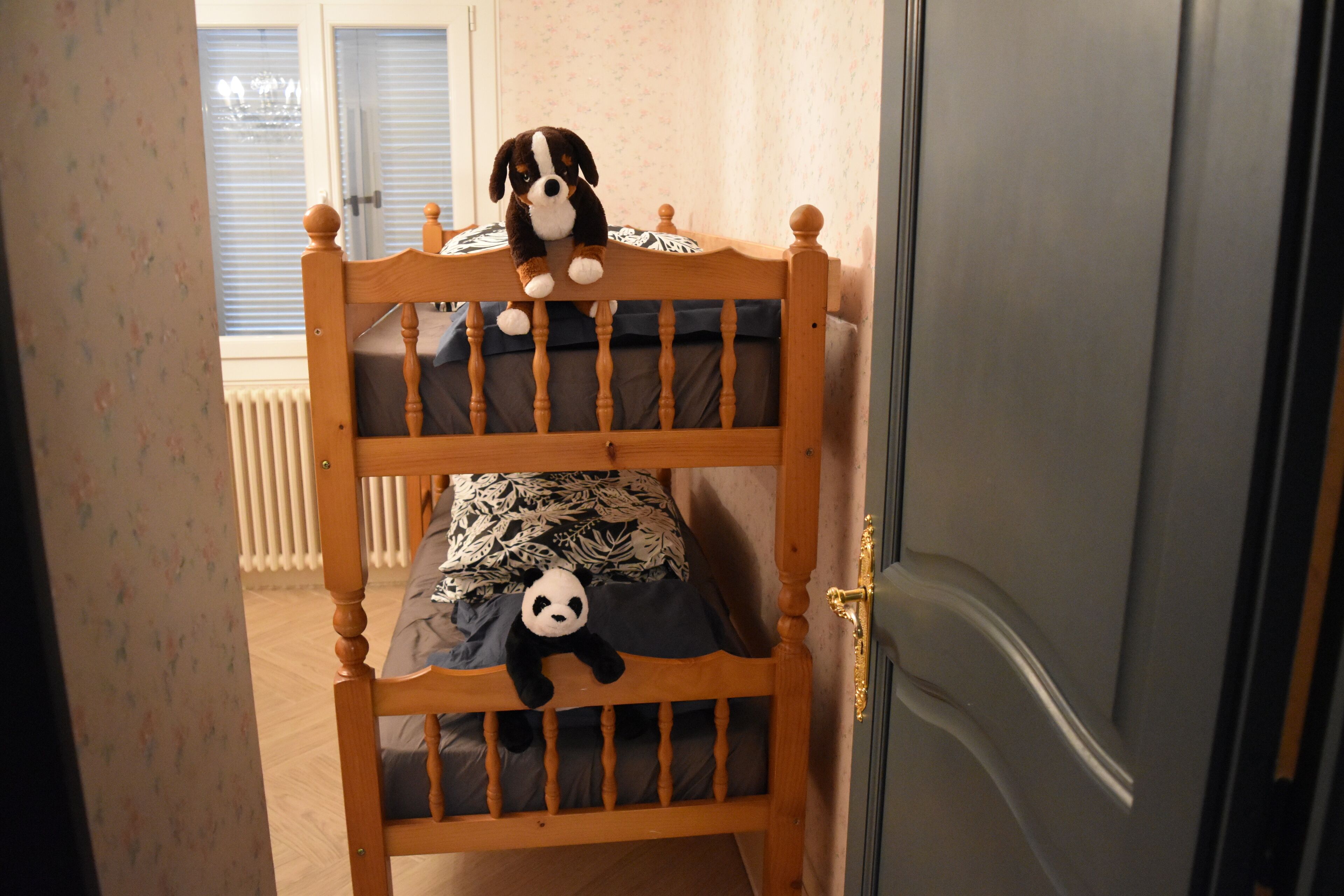Un lit superposé avec un chien en peluche et un jouet panda.