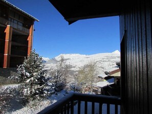 Enjoy breathtaking views of snow-covered mountains from this cozy balcony.