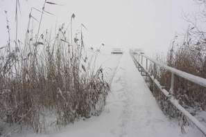 A snow-covered pathway leading to a bench. - 3 room first floor - Apartment Ferienhaus Müritztraum - Ferienwohnungen / (Röbel/Müritz)