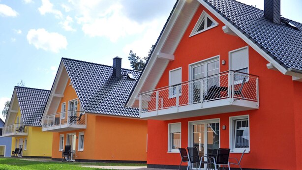 A row of colorful houses with balconies, each featuring a different color. - 3 room first floor - Apartment Ferienhaus Müritzwelle - Ferienwohnungen / (Röbel/Müritz)