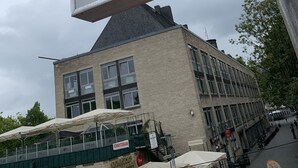 A sign advertising 'Moderne Apartments am Rheingarten' with a view of a building and outdoor seating area. - City Apartments in Köln am Rheingarten (Cologne)