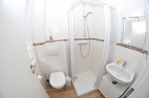 A small, modern bathroom with a shower, toilet, and sink. - 4 room first floor - Apartment Ferienhaus Müritzzauber - Ferienwohnungen / (Röbel/Müritz)