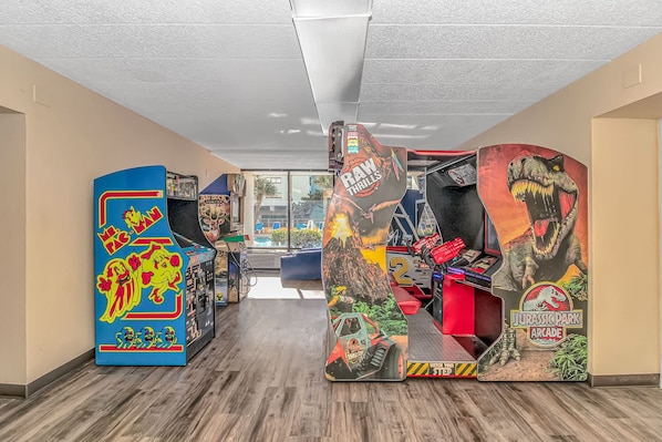 A hallway with arcade machines, including Pac-Man and Jurassic Park Arcade games.