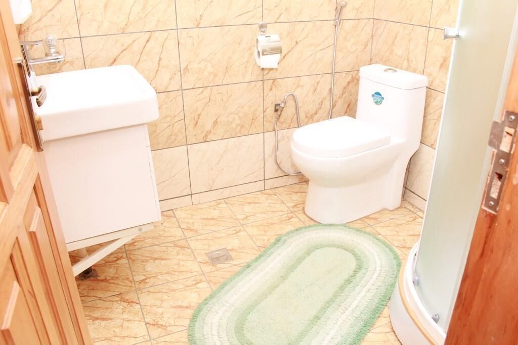 A bathroom with a toilet, sink, and shower.