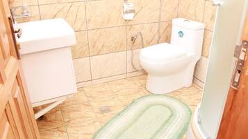 A bathroom with a toilet, sink, and shower.