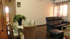 A living room with a glass table, two chairs, a sofa, and a coffee table. - Deutch' Lodges (Yaoundé)
