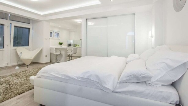 Un dormitorio moderno con una cama grande, un escritorio y una silla.