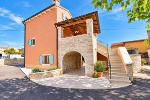 A two-story stone house with a stone archway entrance, a wooden staircase, and a small garden area. - House 2014/28564 (Istria - Žminj), 30000m from the beach (Žminj)