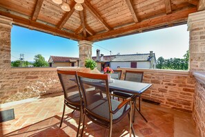 A covered outdoor seating area with a table and chairs, overlooking a residential neighborhood. - House 2014/28564 (Istria - Žminj), 30000m from the beach (Žminj)