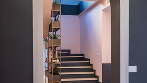 A modern staircase with a minimalist design, flanked by dark walls and a light-colored floor. - Allure Boutique Hotel (Tirana)