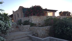 A stone house with a staircase leading to a wooden door. - Lampedusa catatteristic dammuso sea view, 200mt distant, 180° (Lampedusa)