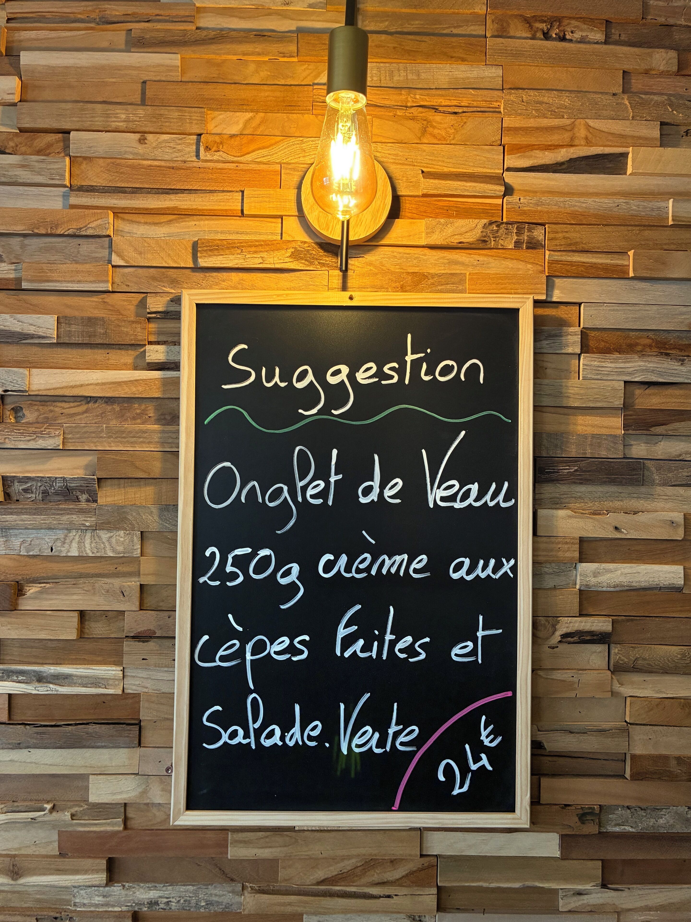 Una pizarra con sugerencia de tortilla de verduras y ensalada, a 24€.