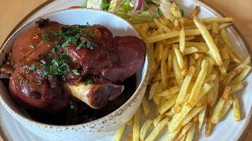 En tallerken med kød, pommes frites og en salat.