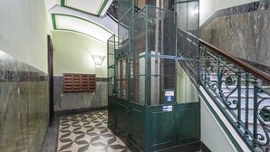 A staircase with metal railings and patterned floor tiles. - GuestHost - Cozy and modern flat 80sqm with all the comfort, convenient for its position in the city center of Turin, very close to the main points of interest of the city as the Egyptian Museum, only 500m away, Piazza Solferino (400m), and Giardini Real (Torino)