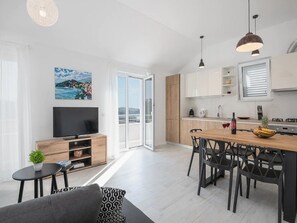 A modern apartment with a living room, dining area, kitchen, and balcony. - Apartment Dolce (Konavle)