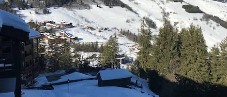 A snow-covered mountain village with buildings and trees.
