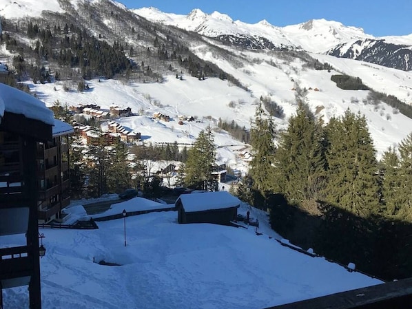 A snow-covered mountain village with buildings and trees.