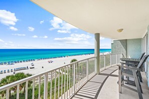A balcony with a view of a beach and ocean.