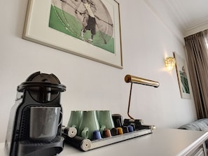 Relax in a stylish space with a framed artwork, wall-mounted light, and a convenient tray with essentials.
