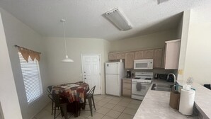 Una cocina compacta con servicios básicos, incluyendo refrigerador, microondas, estufa y pileta.