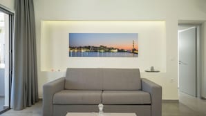 Ein modernes Wohnzimmer mit einem grauen Sofa, einem Tisch mit einem Glaskaraffe und einem Stadtbild über dem Sofa.