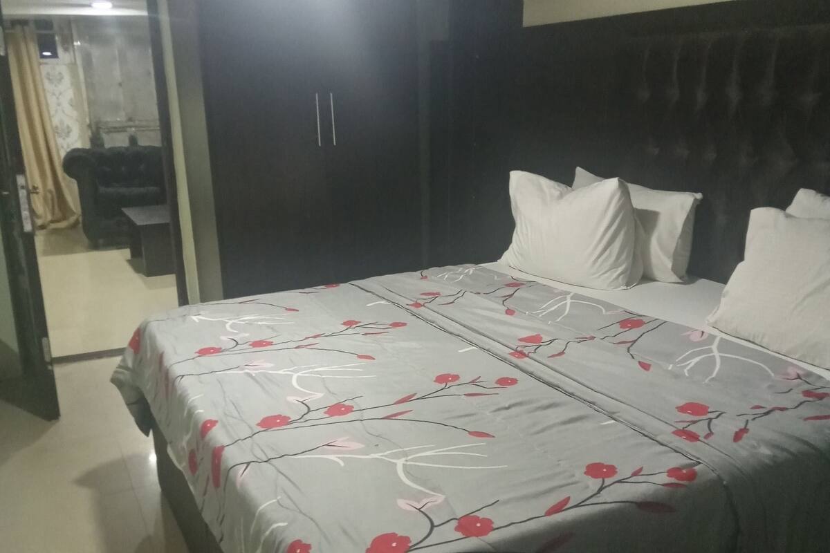 Ein Schlafzimmer mit einem Bett, einem dunklen Kopfteil und einem Kleiderschrank.