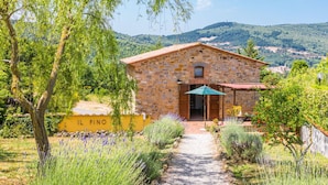 A stone building with a red roof, a gravel path leading to the entrance, and a yellow wall with "IL PINO" written on it. - Cosy apartment for 12 people with private pool, A/C, WIFI, TV, patio and pets allowed (Castelnuovo Di Val Di Cecina)