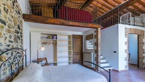 A bedroom with a bed, a desk, and a chair. There is a bookshelf and a window with curtains. - Cosy apartment for 12 people with private pool, A/C, WIFI, TV, patio and pets allowed (Castelnuovo Di Val Di Cecina)