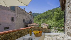 A table set outdoors with a view of a hillside and a building in the background. - Cosy apartment in villa for 3 people with pool, WIFI, TV, patio and pets allowed (Sesto Fiorentino)