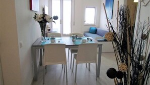 Un comedor con una mesa, sillas y un florero.