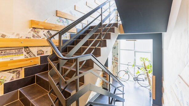A modern staircase with metal railings and wooden steps, leading to a room with a bicycle and a plant. - aappartel boardinghouse city center (Bielefeld)