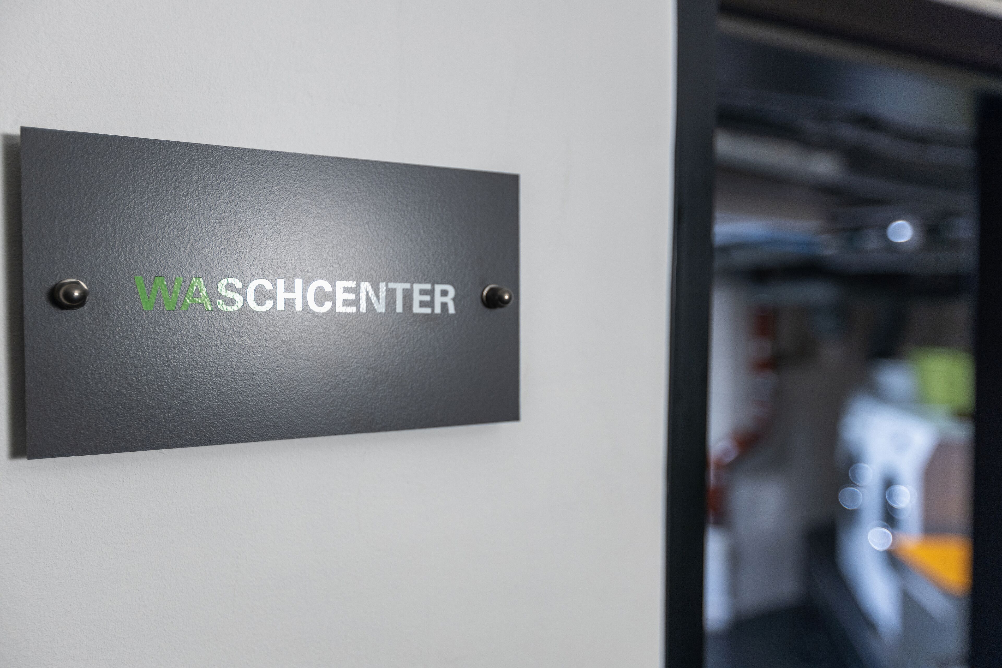 A sign with the text 'WASHCENTER' mounted on a wall.