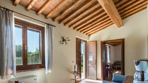 Habitació amb sostre de fusta, una taula de dinar, un sofà blau i una màquina de cafè.