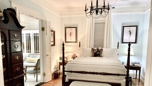 A bedroom with a four-poster bed, a wooden dresser, a chandelier, and a patterned rug. - Luxurious and Relaxing Elegance Upstairs 🚭 (St. Augustine)