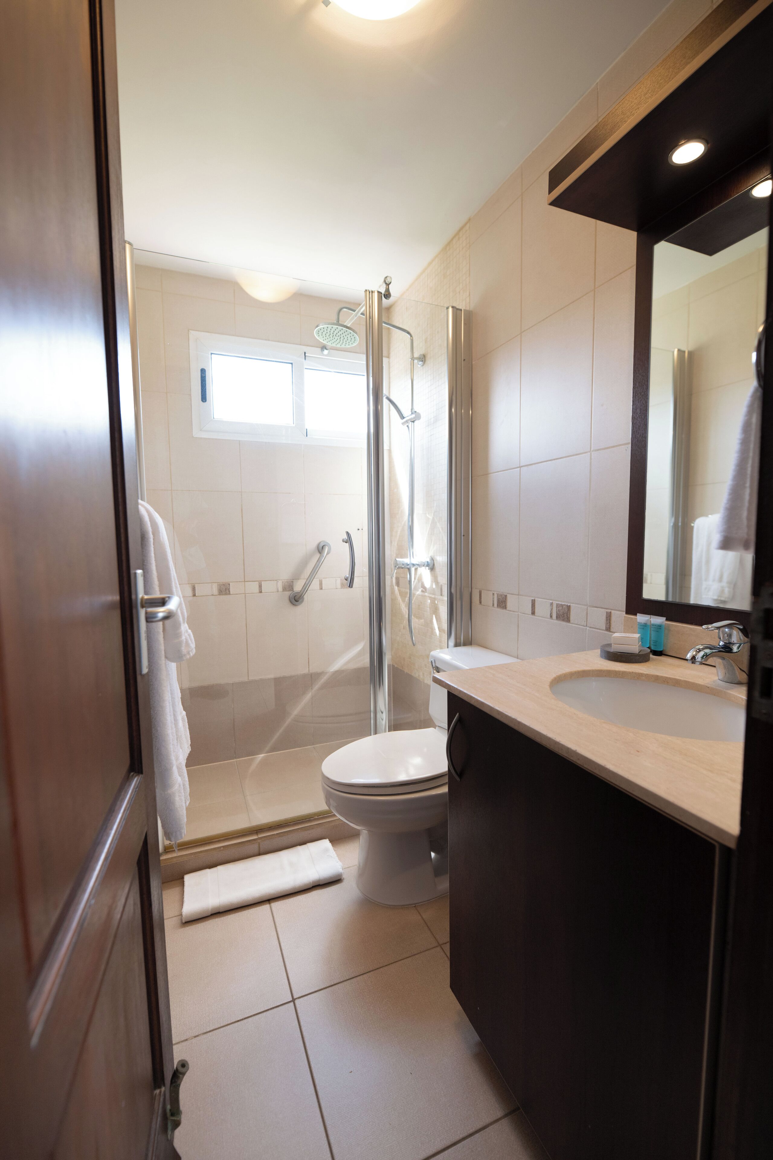 Une salle de bain équipée d’une douche, de toilettes, d’un lavabo et d’un miroir.