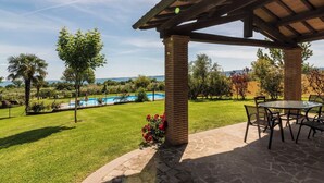 A covered patio with stone flooring, a pool, and a view of the sea. - Lovely apartment in villa for 6 guests with WIFI, pool, TV and terrace (Lake Bolsena)