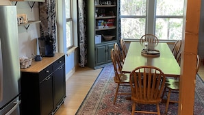 A kitchen with a dining area, wooden cabinets, a refrigerator, and a rug. - Spacious 3-Story Home, 4 bedrooms, Sleeps 12, Easy Trailer Parking (Detroit)