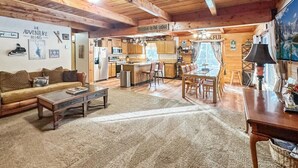 A cozy lodge interior with a living room, dining area, and kitchen.