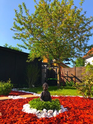 Stroll through the serene garden, surrounded by vibrant foliage and a tranquil Buddha statue.