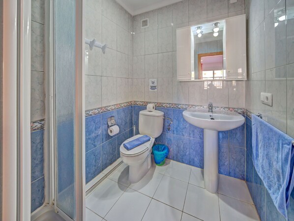 A bathroom with a toilet, sink, and shower.