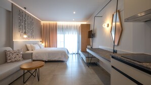 A modern hotel room with a bed, sofa, and a small wooden table. - Elixia (Nafplio)