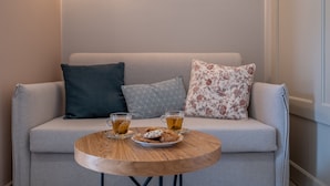A cozy seating area with a round wooden table, two cups of tea, and cookies. - Elixia (Nafplio)