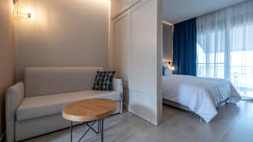 Apartamento Deluxe, vistas al mar | Sala de estar | Televisión de pantalla plana de 32 pulgadas con canales digitales