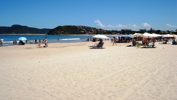 A beach with umbrellas and people. - MODERN HOUSE 4 SUITES WITH POOL IN GERIBA (Campo de Pouso)