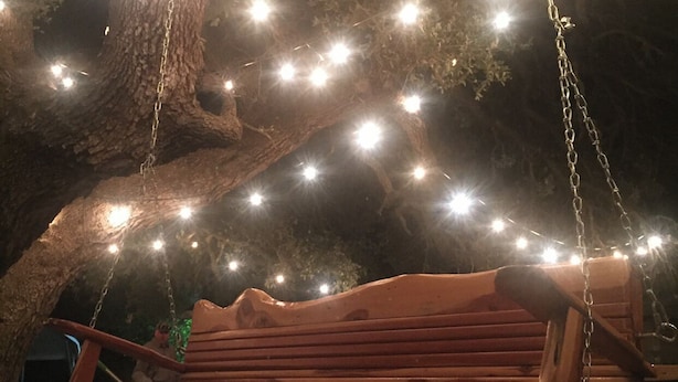 A wooden swing bench under a tree with string lights. - Beautiful Texas Hill country, amazing views, and farm living (Florence)