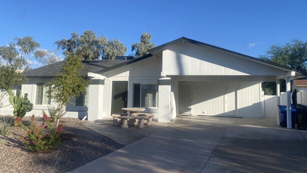 A modern house with a covered patio, a concrete driveway, and a cactus plant. - Spring Training 3B/2B close to everything (Mesa)