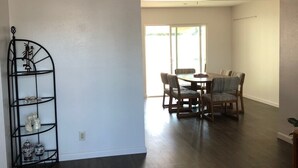 A spacious living area with a dining table and chairs, a ceiling fan, and a decorative metal shelf. - Spring Training 3B/2B close to everything (Mesa)