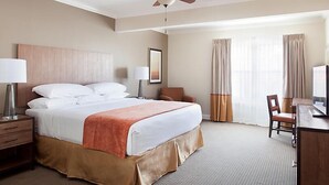 A hotel room with a large bed, a desk with a chair, a television, and a ceiling fan. - Franconia Notch State Park - South Mountain Resort (Lincoln)