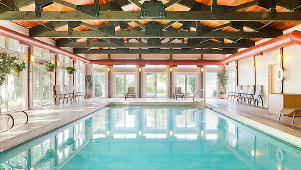 An indoor swimming pool with a wooden ceiling and large windows. - Franconia Notch State Park - South Mountain Resort (Lincoln)